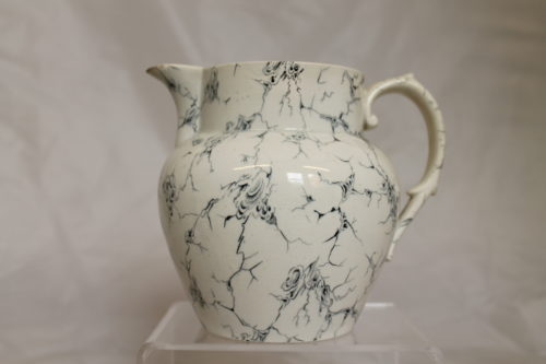 A white jug with a handle on the right hand side. The jug is covered in blue lines.