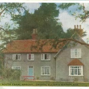 A colour postcard showing a grey coloured house with a red tiled roof. It has light blue front door with a becnh in front of it. There are trees to the side and behind the house and a garden in front of it. The words Nuneaton - South Farm, Arbury, George Eliot's birthplace are typed along the bottom.