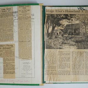Open scrapbook. Newspaper articles relating to George Eliot and stuck onto both pages.