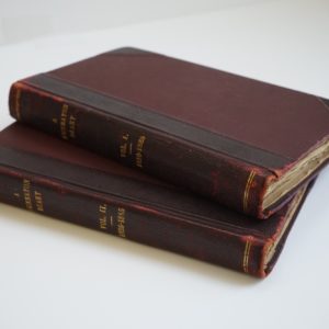 Two books stacked with brown covered.