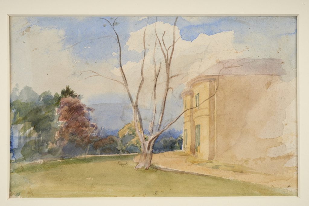 Watercolour painting showing the side of a large house on the right hand side. A tree with bare branches is on a lawn in front of the trees and green and brown trees are on the left hand side. Blue sky and clouds are overhead. 