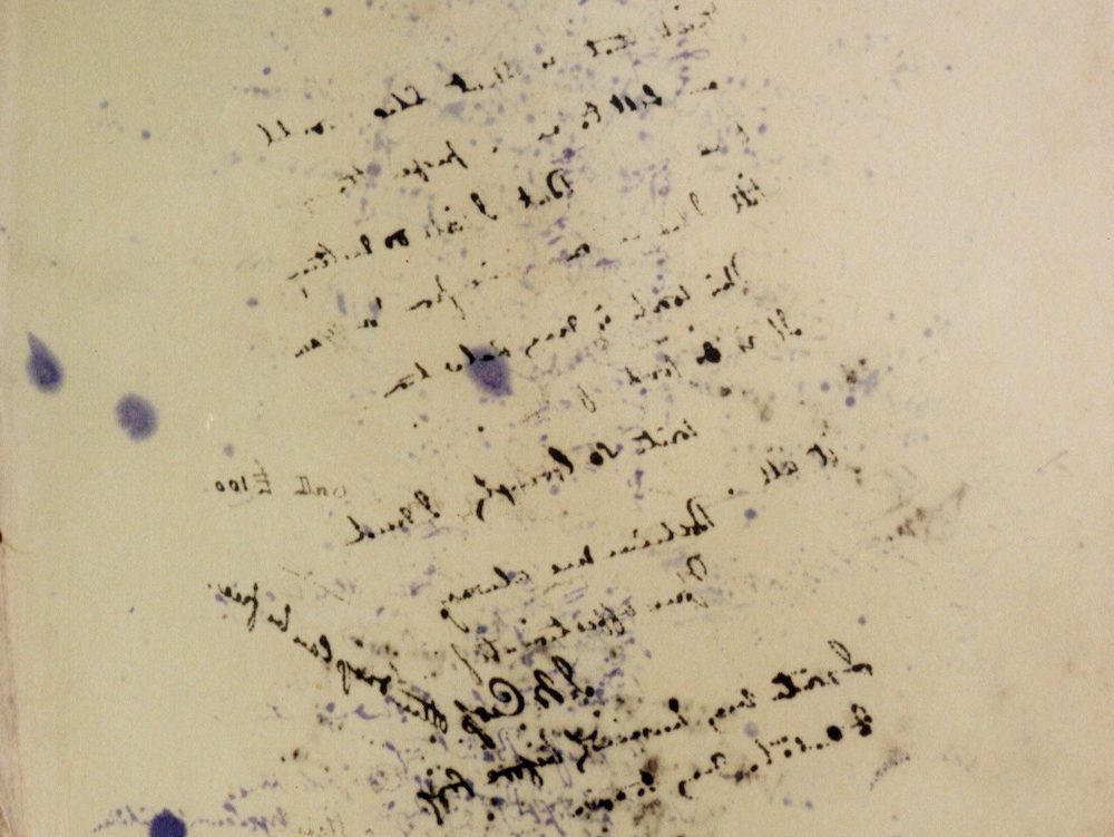 Sheet of cream coloured blotting paper viewed through a mirror. Lines of writing can be seen which include some names and the amount of £100.